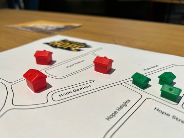 A simple board game prototype made with a piece of paper and tokens borrowed from another game.